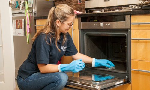 Cleaner tackling a dirty Oven Cleaning London